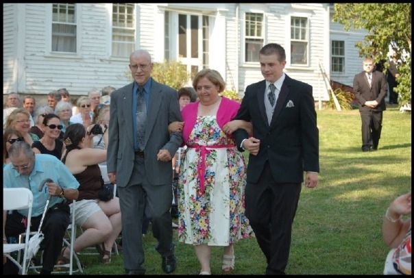 Paul arm in arm with his wife and son at his son's wedding